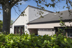 Nether Davah House with bushes and tree in the foreground