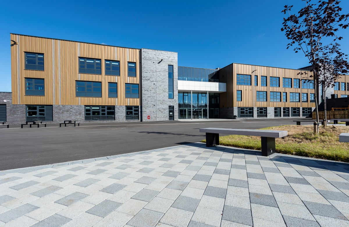 Inverurie Community Campus building in background, with stone walkway and bench in foreground