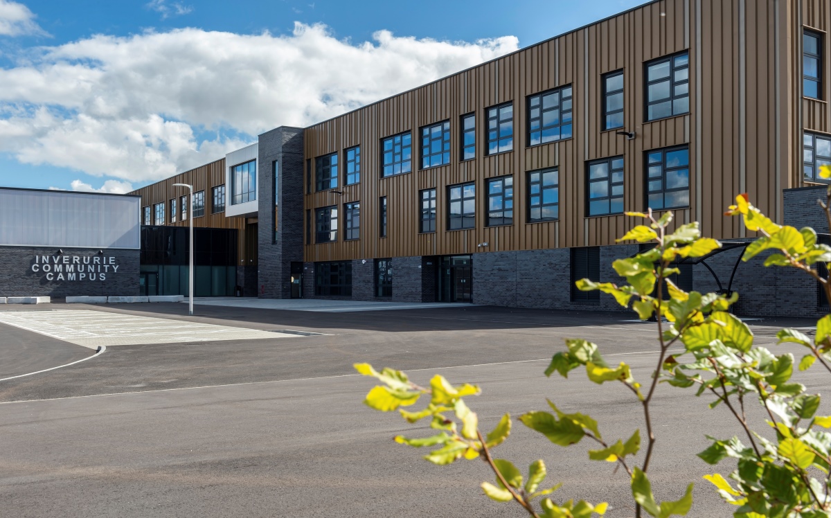 Community campus building with lots of windows and large parking space in front