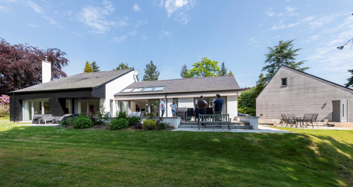 Back view of the Beeches house showing patio with people standing around and grass area in foreground